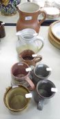 THREE VARIOUS SIZED STUDIO POTTERY JUGS AND FOUR POTTERY TANKARDS