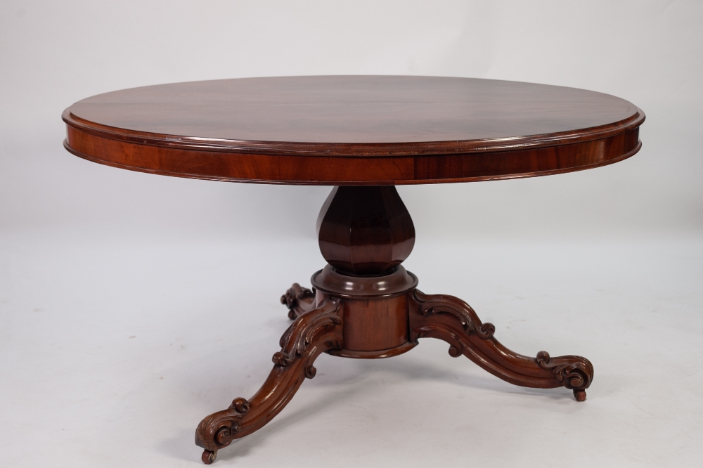 VICTORIAN CARVED AND FIGURED MAHOGANY LOO TABLE, the flame cut oval tilt top above a heavy base with