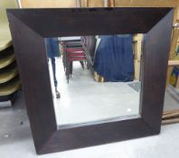 A RECTANGULAR BEVELLED EDGE WALL MIRROR IN BROAD PLAIN EBONISED FRAME