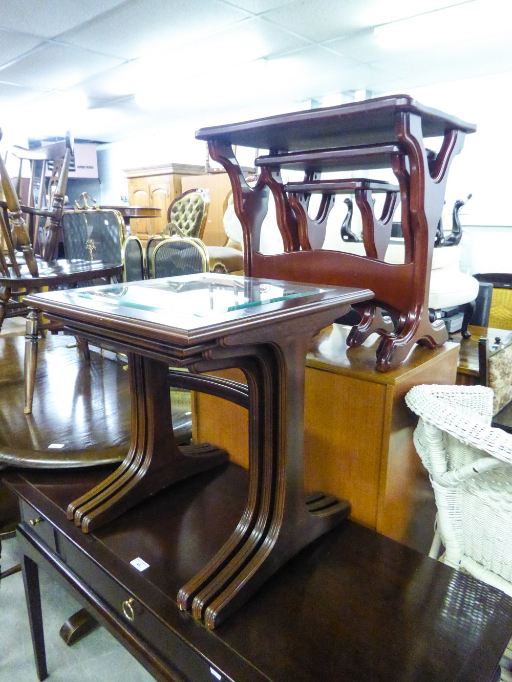 MAHOGANY WAVY OBLONG NEST OF COFFEE TABLES, ON CHEVAL SUPPORTS AND A SIMILAR NEST OF THREE OBLONG