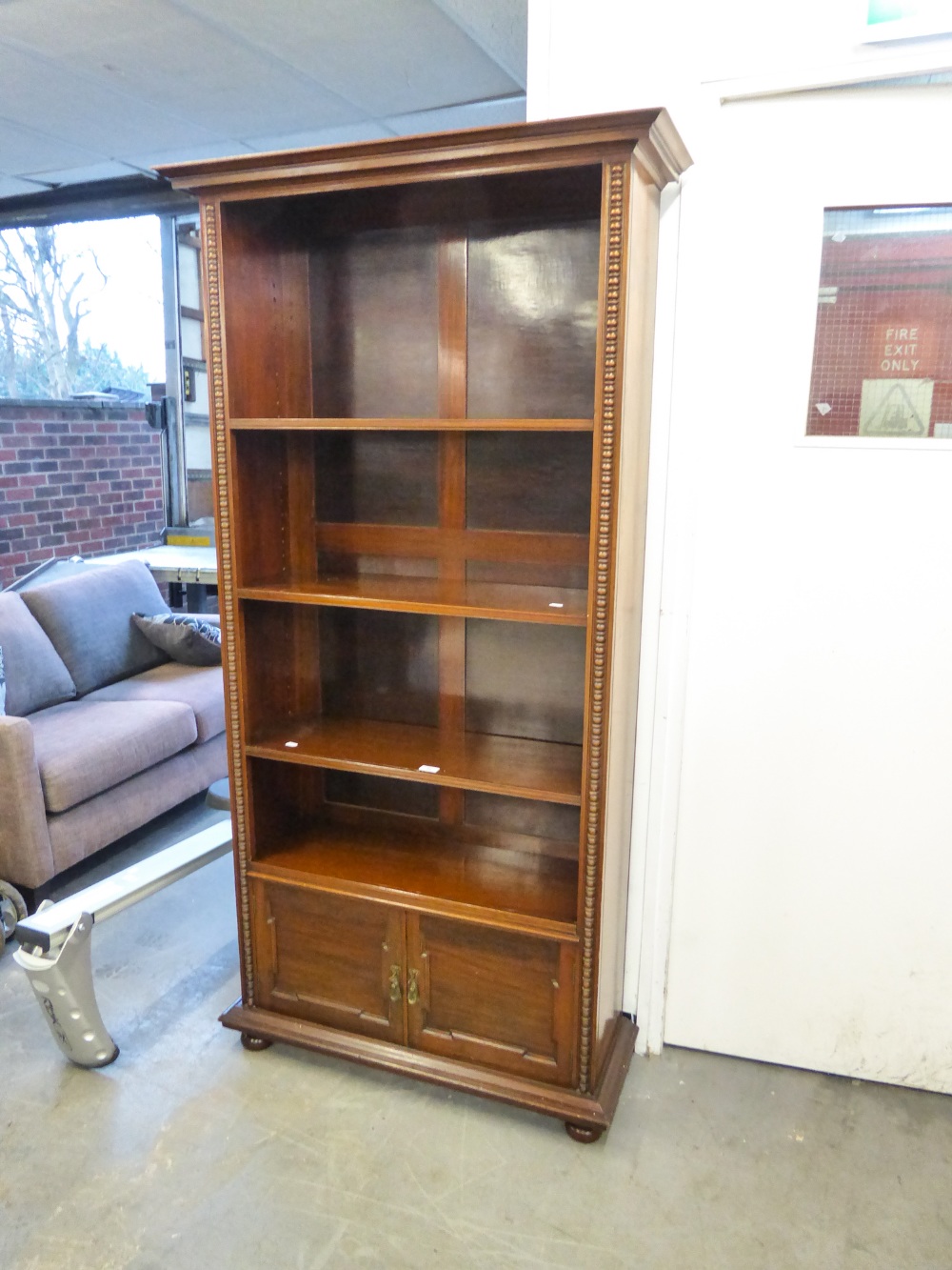 MAHOGANY TALL OPEN BOOKCASE HAVING FOUR SHELVES AND BASE CUPBOARD, STANDING ON BUN FEET, 74" (187.