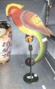 A PAINTED METAL BALANCING AND ROCKING PARROT ON STAND