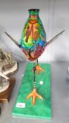 AN ORNAMENTAL PAPIER MACHE MODEL OF A BIRD, ON OBLONG BASE, 13 1/2" HIGH