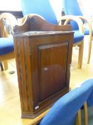 A SMALL MAHOGANY CORNER CUPBOARD