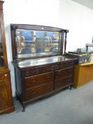 A MAHOGANY MIRROR BACK SIDEBOARD, THE BASE HAVING THREE SHORT DRAWERS WITH CARVING OVER TWO BANKS OF