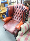 A TWENTIETH CENTURY REPRODUCTION CHESTERFIELD WINGED BACK ARMCHAIR, COVERED IN BUTTONED RED LEATHER