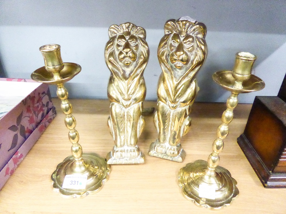 PAIR OF EARLY TWENTIETH CENTURY BRASS ANDIRONS IN THE FORM OF STYLIZED SEATED LIONS, 10" (25.4cm)