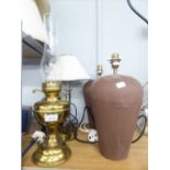 A BRASS OIL LAMP, TWO BROWN POTTERY TABLE LAMPS AND SHADES AND ANOTHER