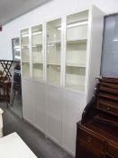 TWO MODERN WHITE ENAMELLED FINISH TALL DISPLAY CABINET EACH WITH TWO GLAZED DOORS, 2'6" WIDE