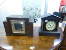 A VICTORIAN MANTEL CLOCK IN BLACK SLATE ARCHITECTURAL CASE AND AN OAK CASED MANTEL CLOCK (2)