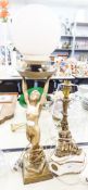 A MARBLE AND BRASS TABLE LAMP, STYLIZED BRASS STAND WITH TWO CHERUBS PERCHED ON A SHAPED MARBLE