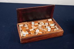 ORIENTAL BONE AND BAMBOO MAH JONG SET in a wooden slide top box with incised Chinese inscription