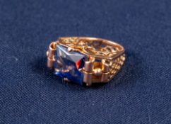 GOLD AND SYNTHETIC SAPPHIRE DRESS RING with an emerald cut sapphire, in a four claw setting with