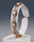 9ct GOLD BRACELET with eight fancy pierced oval links each set with a cabochon synthetic oval