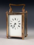 A MID TWENTIETH CENTURY BRASS CASED CARRIAGE CLOCK of typical form with oblong white dial, black