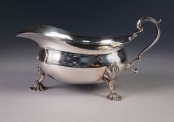 PRE-WAR SILVER SAUCE BOAT OF GEORGIAN DESIGN with everted cut rim and scroll handle, standing on
