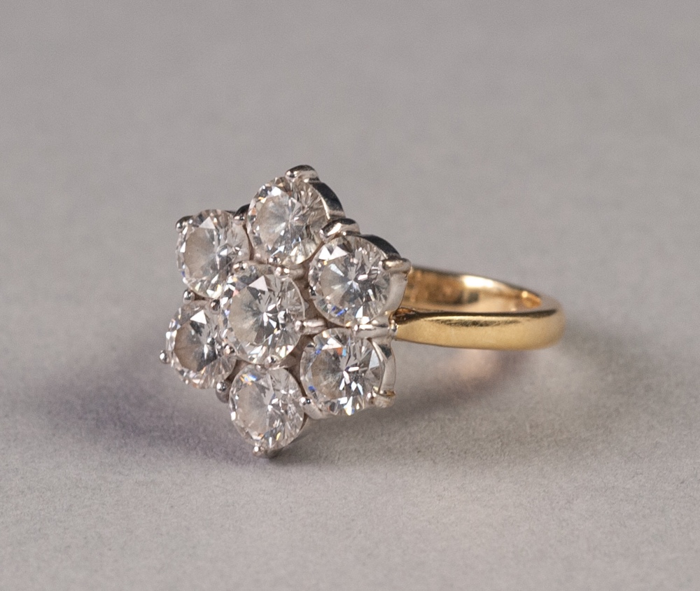 18ct GOLD AND DIAMOND DAISY CLUSTER RING, set with seven round brilliant cut diamonds, the centre