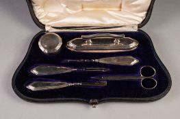 EDWARDIAN SILVER MANICURE SET OF SIX PIECES, in shaped and fitted rococo case comprising a nail