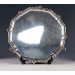 EARLY 20th CENTURY SILVER SALVER with shaped shell work border, standing on three claw feet,