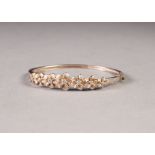 SILVER HINGED OPENING NARROW BANGLE, the top with seven pink enamelled flower heads, each set with a