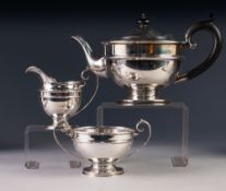 PRE-WAR THREE PIECE SILVER TEA SERVICE OF CIRCULAR PEDESTAL FORM, the teapot with blackwood handle