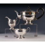 PRE-WAR THREE PIECE SILVER TEA SERVICE OF CIRCULAR PEDESTAL FORM, the teapot with blackwood handle