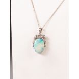 14k WHITE GOLD PENDANT, with an oval opal, 2cm x 1.5cm in a four claw setting with fancy foliate