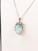 14k WHITE GOLD PENDANT, with an oval opal, 2cm x 1.5cm in a four claw setting with fancy foliate