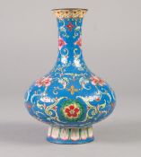 A CHINESE QING DYNASTY CANTON ENAMEL VASE of compressed baluster form rising from a spreading stem