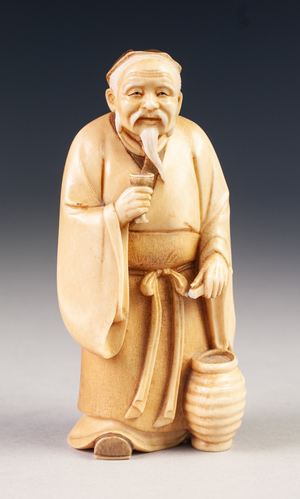 GOOD JAPANESE MEIJI PERIOD ONE PIECE CARVED IVORY BEARDED MALE FIGURE, holding a goblet in his