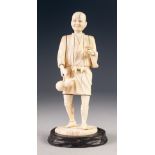 JAPANESE MEIJI PERIOD CARVED SECTIONAL IVORY OKIMONO, modelled as a man, standing, carrying a double
