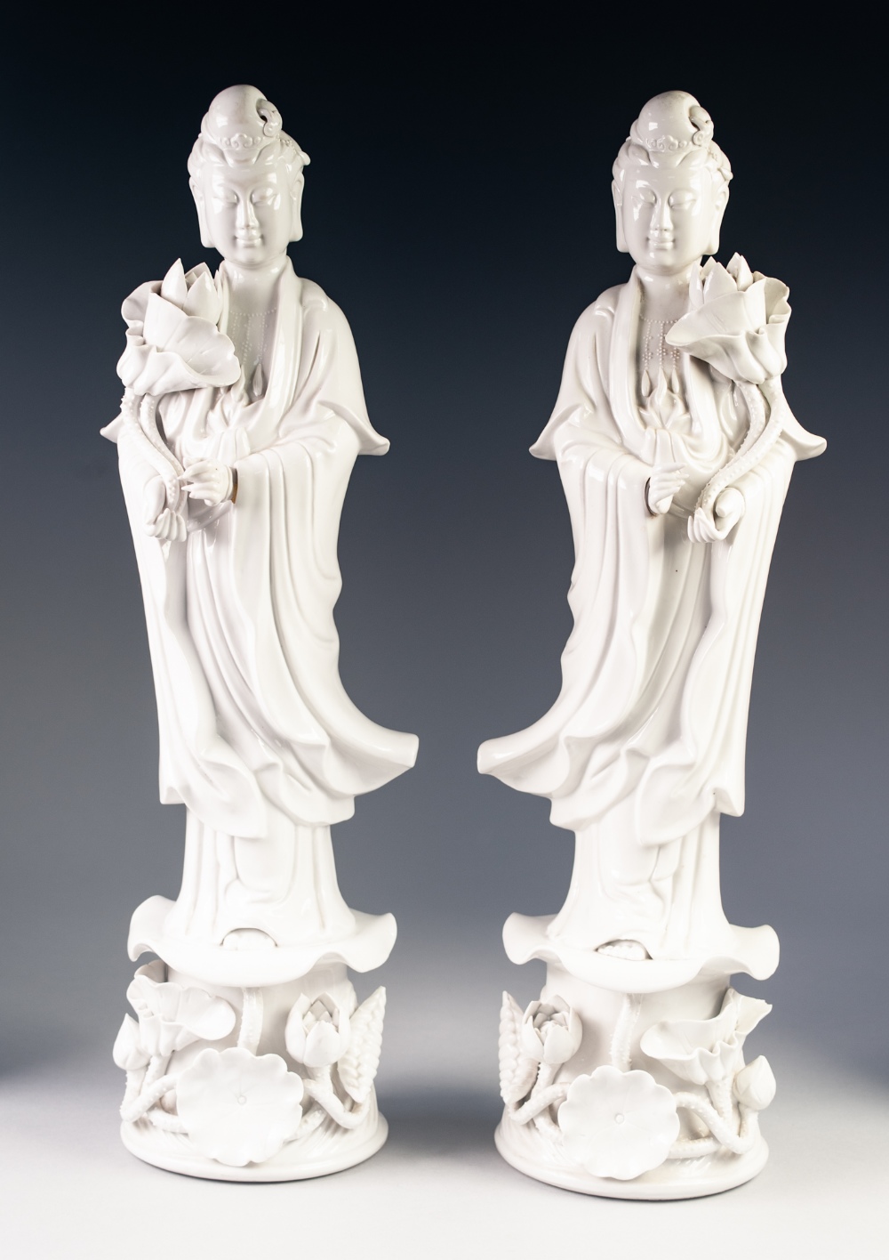 A PAIR OF TWENTIETH CENTURY CHINESE MIRROR IMAGE BLANC DE CHINE PORCELAIN FIGURES, of Guanyin,