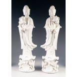 A PAIR OF TWENTIETH CENTURY CHINESE MIRROR IMAGE BLANC DE CHINE PORCELAIN FIGURES, of Guanyin,