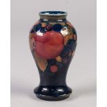 WILLIAM MOORCROFT POMEGRANATE PATTERN TUBE LINED POTTERY SMALL VASE, of baluster form, decorated