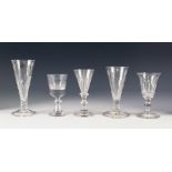 FIVE ANTIQUE DRINKING GLASSES, comprising: TWO ALE GLASSES, both with part wrythen fluted bowls, one