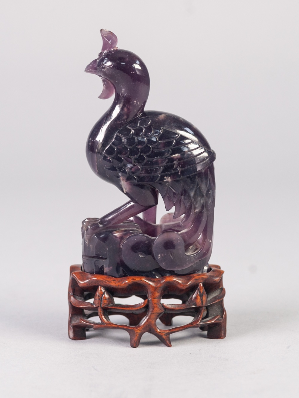 A TWENTIETH CENTURY CHINESE CARVED AMETHYST QUARTZ PHOENIX, on openwork wooden stand, 4 1/2" (11. - Image 2 of 2