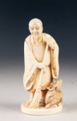 A GOOD JAPANESE MEIJI PERIOD ONE PIECE CARVED IVORY FIGURE, a bearded man holding a bamboo handled