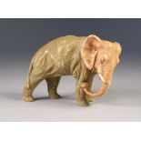 ROYAL DUX STYLE PORCELAIN MODEL OF AN ELEPHANT, painted in muted tones and git and modelled