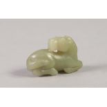 SMALL AGED CHINESE CELADON JADE MODEL OF A RECUMBENT HORSE 2" (5cm) long