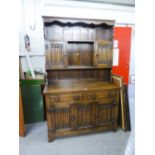 A REPRODUCTION OAK DRESSER WITH LINEN-FOLD PANELS, TWO LONG DRAWERS OVER THREE CUPBOARD DOORS
