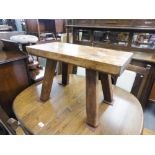 A RUSTIC WOODEN LOW RECTANGULAR TOP TABLE/STAND ON SPREADING RECTANGULAR BLOCK LEGS