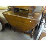 AN OAK GATELEG TABLE, ON BARLEY TWIST SUPPORTS