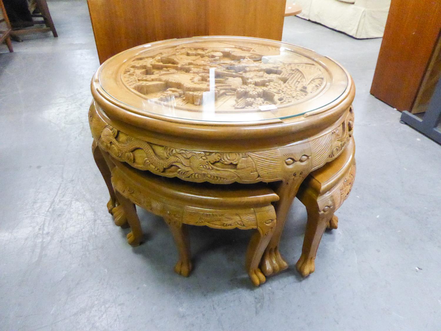 A NEST OF SOUTH EAST ASIAN CIRCULAR PROFUSELY CARVED TABLE WITH FOUR NESTING TABLES