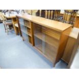 A TEAK LOW BOOKCASE WITH GLASS SLIDING DOORS