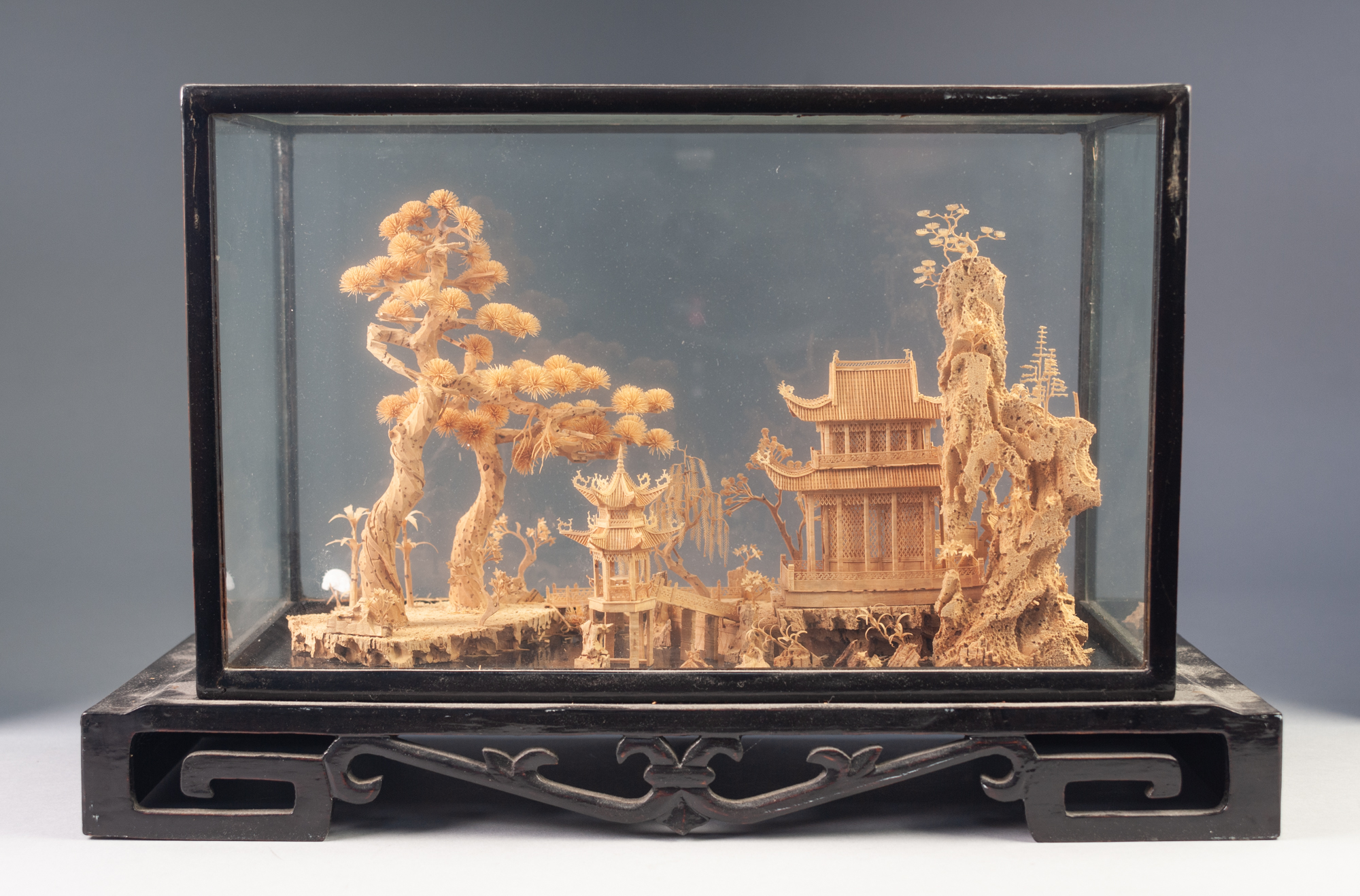 EARLY TWENTIETH CENTURY ORIENTAL CARVED CORK DIORAMA, depicting a temple and trees in a river