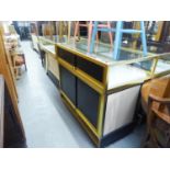 FOUR MODERN GILT METAL EDGED ENCLOSED AND GLASS TOPPED SHOWROOM DISPLAY CASES