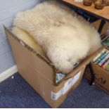 A PAIR OF NATURAL SHEEPSKIN RUGS AND FOUR LARGE CUSHIONS