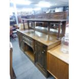 AN EDWARDIAN OAK SIDEBOARD, HAVING RAISED MIRROR BACK, THE SHELF OVER THREE BEVEL GLASS SECTIONS,