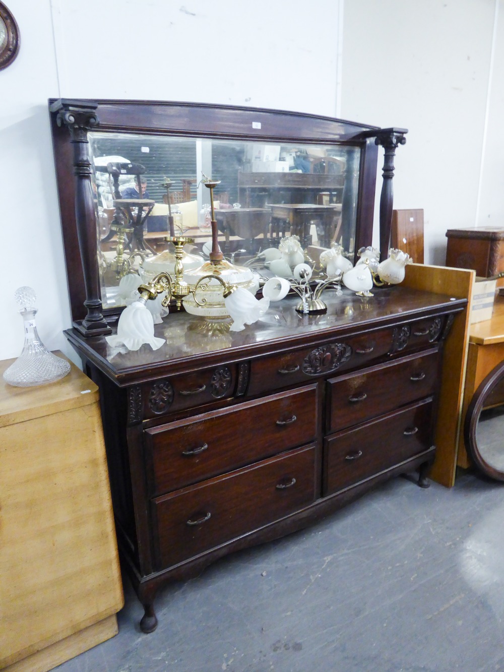 A MAHOGANY MIRROR BACK SIDEBOARD, THE BASE HAVING THREE SHORT DRAWERS WITH CARVING OVER TWO BANKS OF