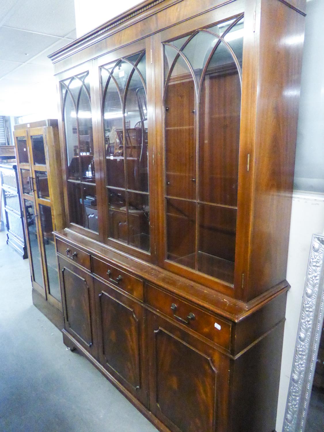 A MODERN REPRODUCTION MAHOGANY BOOKCASE, WITH ASTRAGAL GLASS UPPER SECTION, DRAWERS AND CUPBOARDS